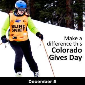 "Make a difference this colorado gives day December 5th." Skier with "Blind skier" vest skiing down snowy slope.