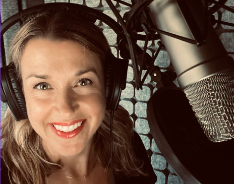 Nicola smiling in a studio with headphones