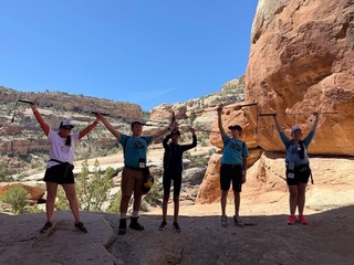 A picture of Penn and 4 athletes in Devil's Kitchen holding their Urban Xplorer canes above their heads.